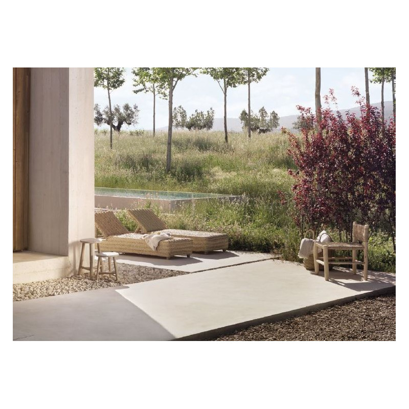 Imagen de un jardín mediterráneo con dos tumbonas de esparto y mobiliario accesorio de madera.