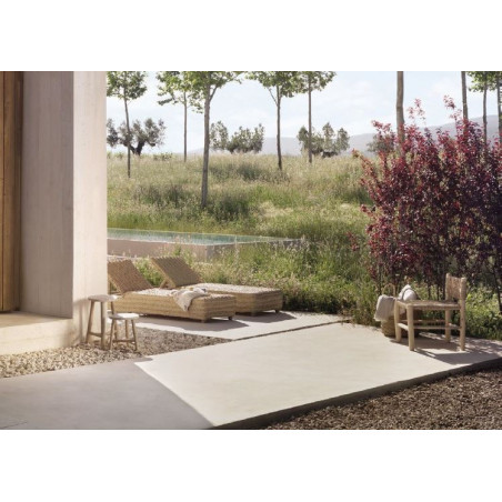 Imagen de un jardín mediterráneo con dos tumbonas de esparto y mobiliario accesorio de madera.