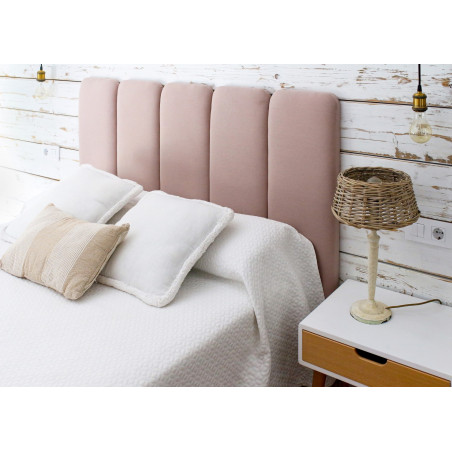 Dormitorio con cabecero tapizado en tela Nattur Cotton, color Rosa Vintage, con volúmenes verticales. Serie C