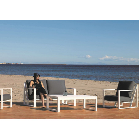 En una playa, conjunto de 5 plazas para terraza, en aluminio blanco y cojinería gris, con mesita de centro a juego