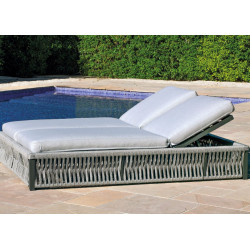 Tumbona doble reclinable en color gris, junto a una piscina